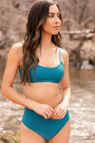 Woman enjoying outdoors in two-piece swimsuit featuring top with a scoop neckline designed for adventure.